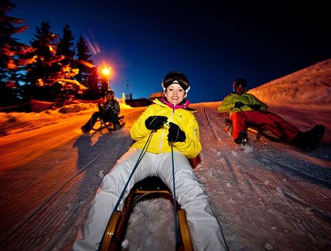 Toboggan fun in the night on the 7km long natural toboggan run of the Hochwurzen